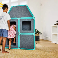 Children playing with a playhouse in a living room with a sale banner on top.