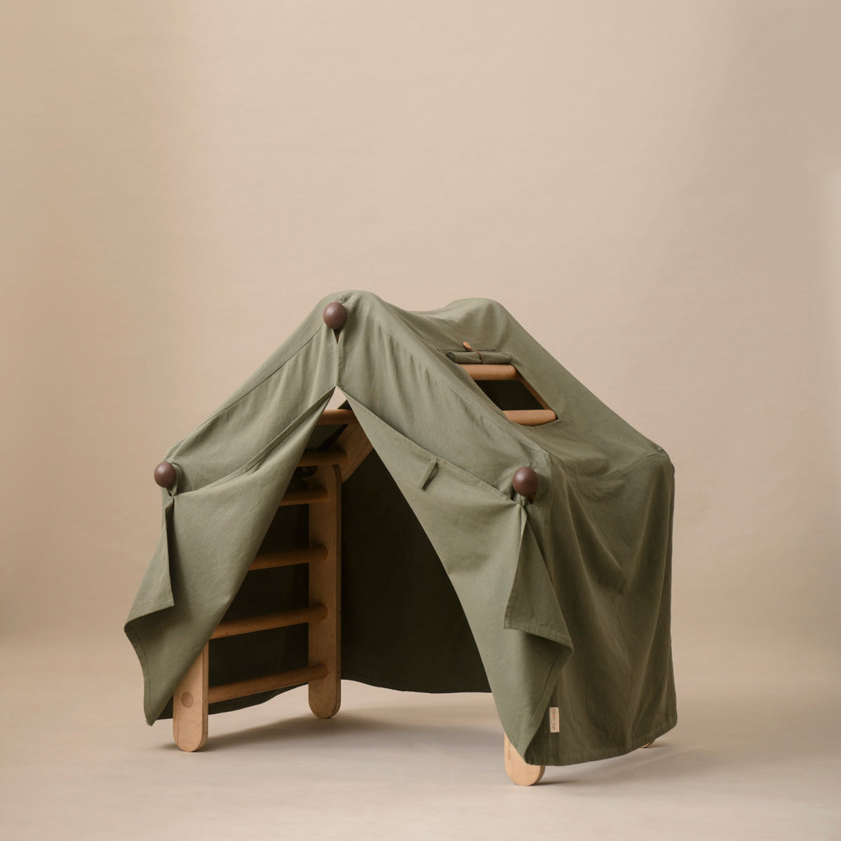 Green tent-like structure on wooden legs against a beige background